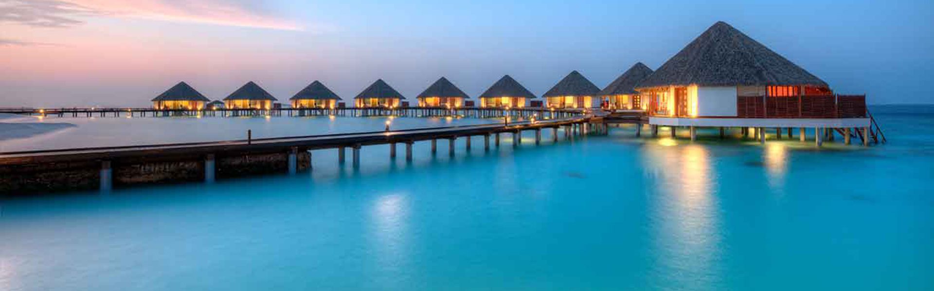 Water villas on Maldives resort island in sunset