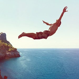 Mann springt von Klippe ins Meer